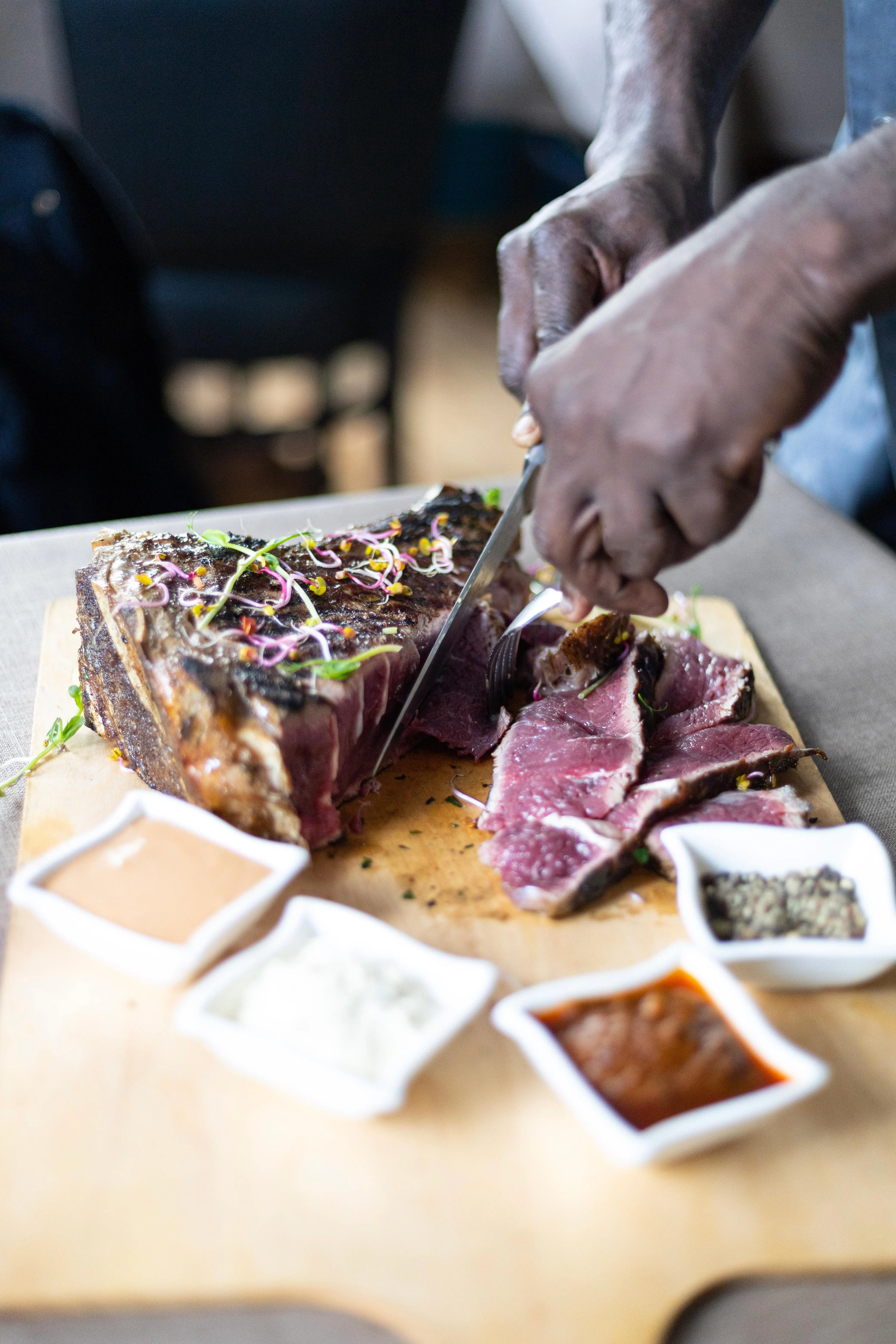 Carving a côte de bœuf with micro-herbs