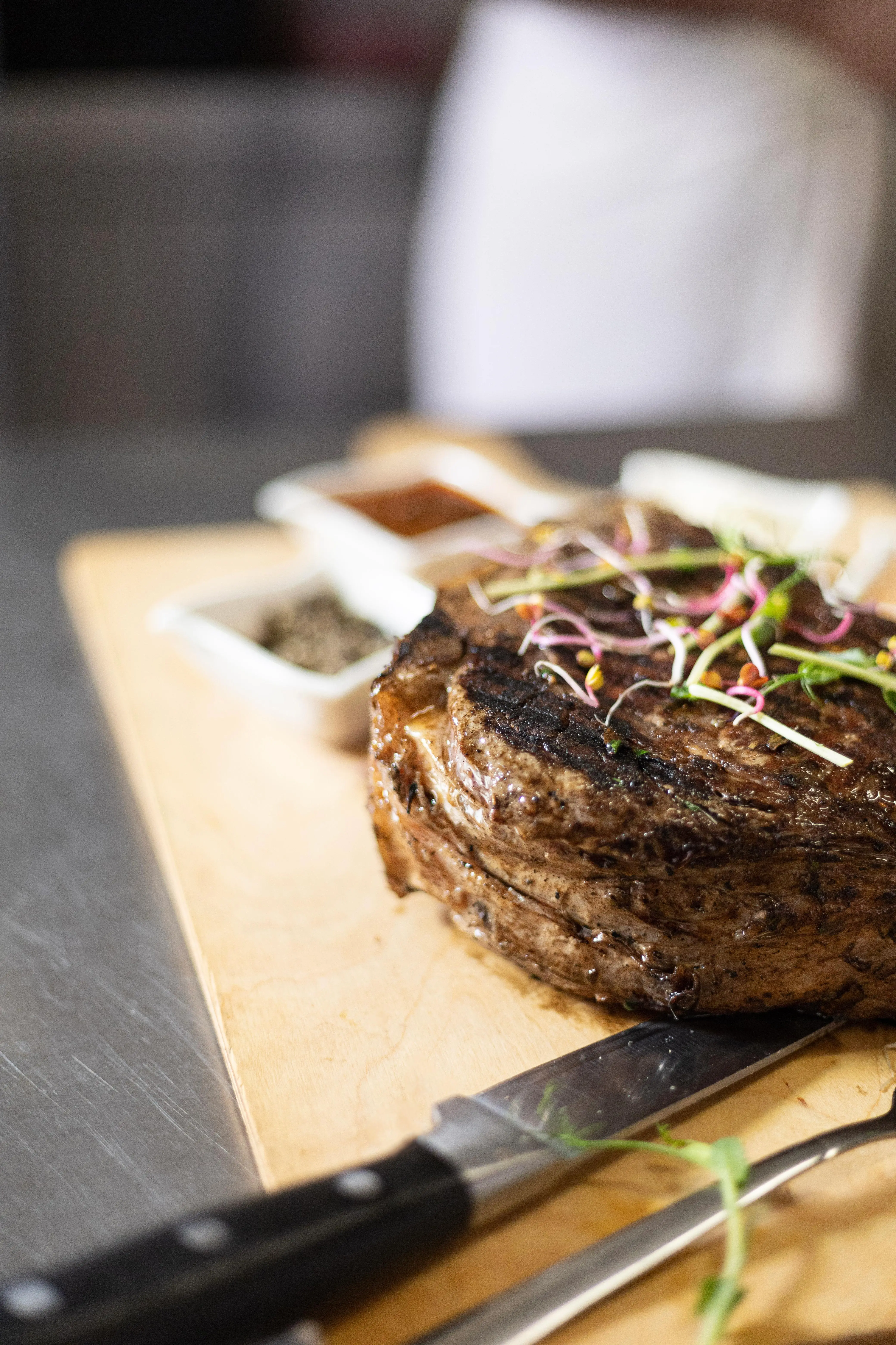 Bone-in côte de bœuf on a board with sauces