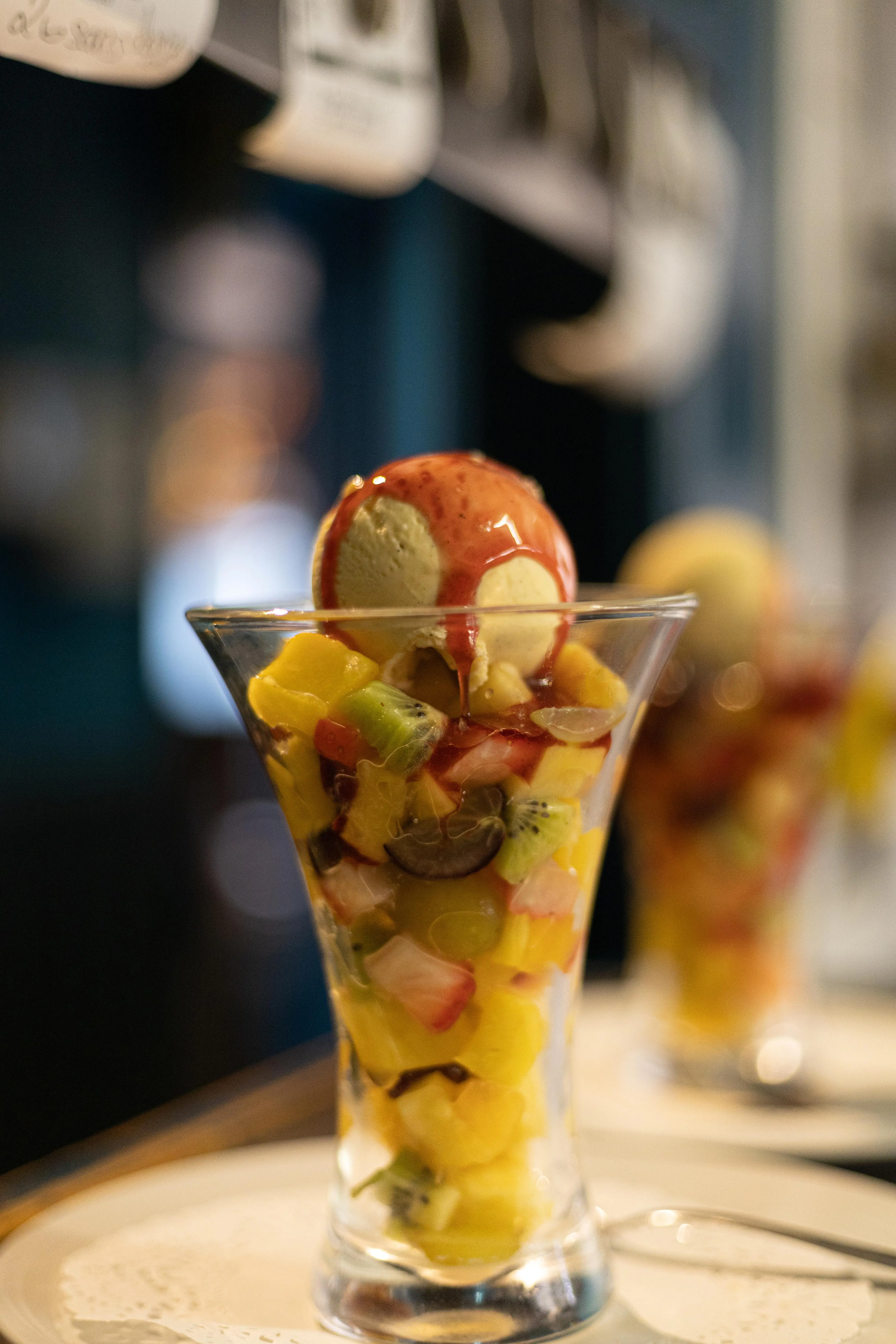 Cup of fruit salad, ice cream and coulis